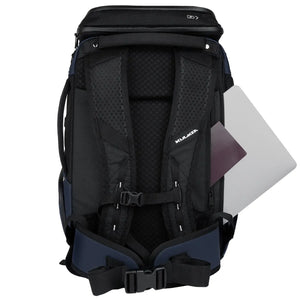 A black and navy blue KLEERA backpack shown from the back, with a silver laptop partially tucked into the side pocket, on a solid white background.
