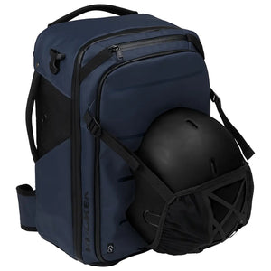 A navy blue and black ski backpack shown with a black ski helmet resting in its front storage pocket, set against a plain white background.
