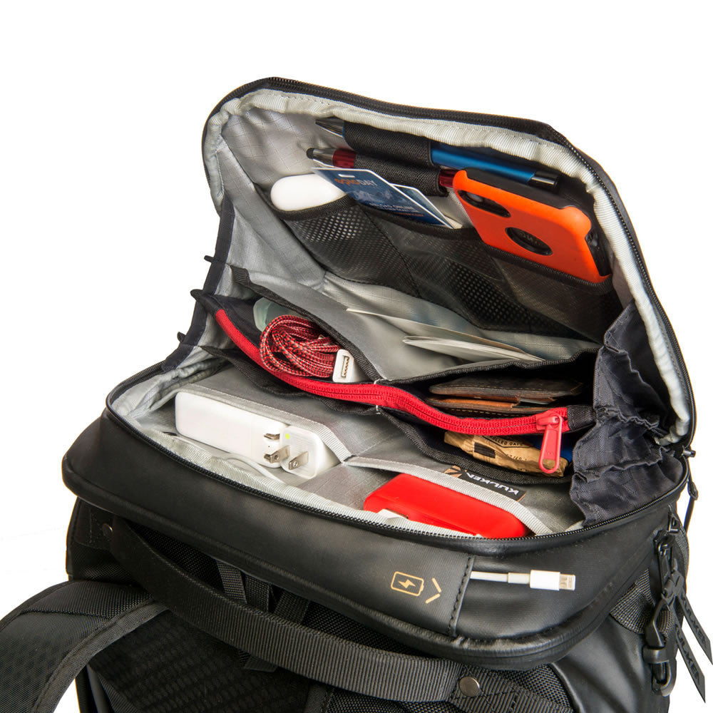 Open backpack with various items including a phone, cable, and power bank on a white background