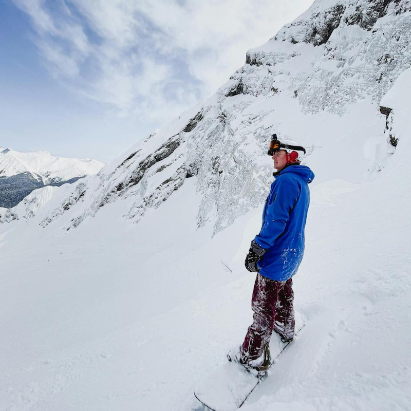Snowboarder navigating mountain in snow