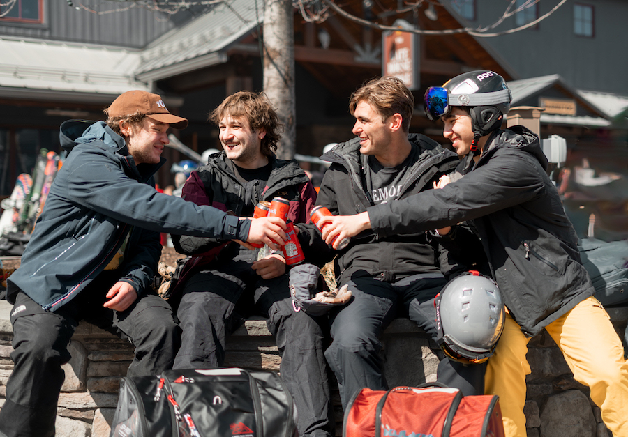 Group of friends enjoying apres ski at mountain base in spring