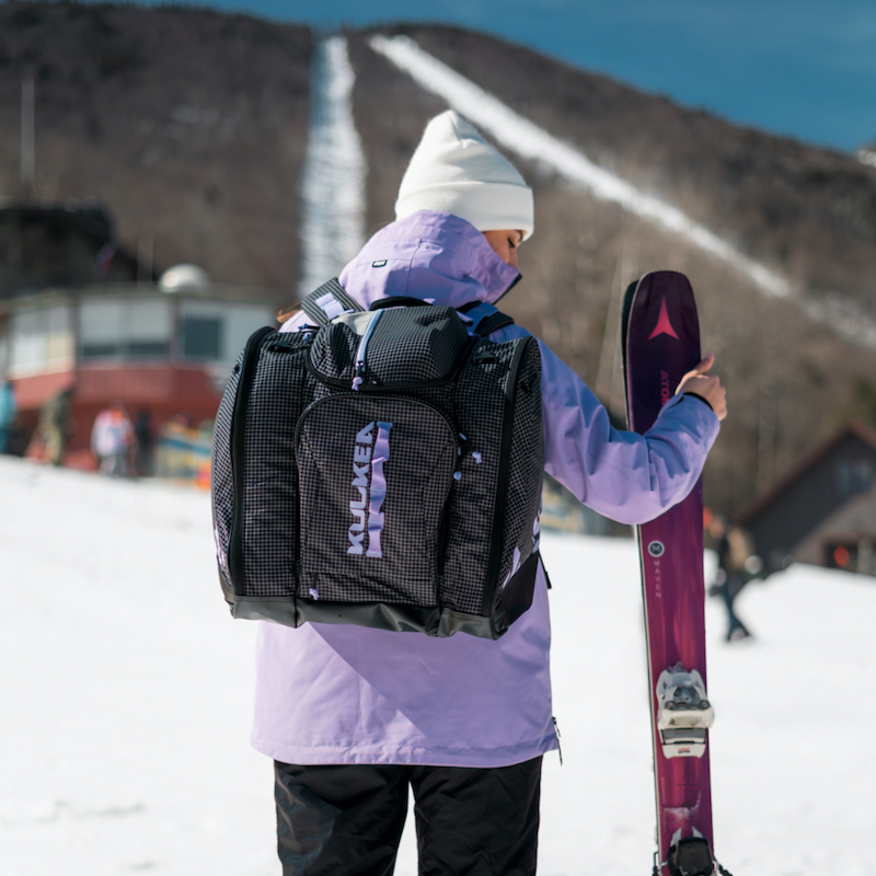 Woman with kulkea powder trekker ski boot bag on her back at mountain