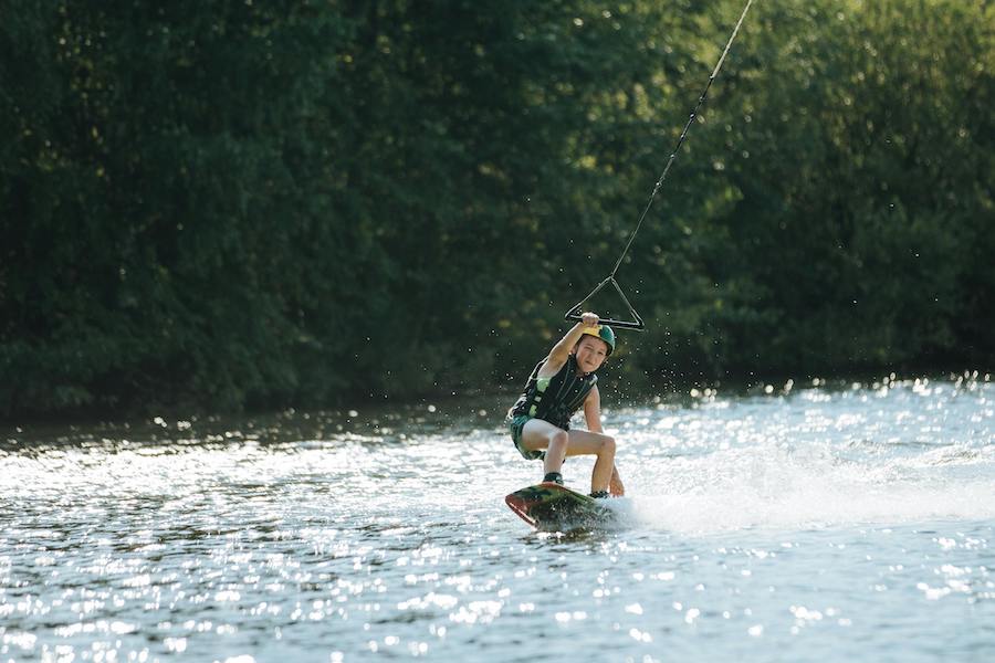 Young boy wakeboarding in a lake