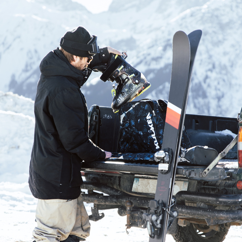 Male skier unloading gear out of truck at mountain