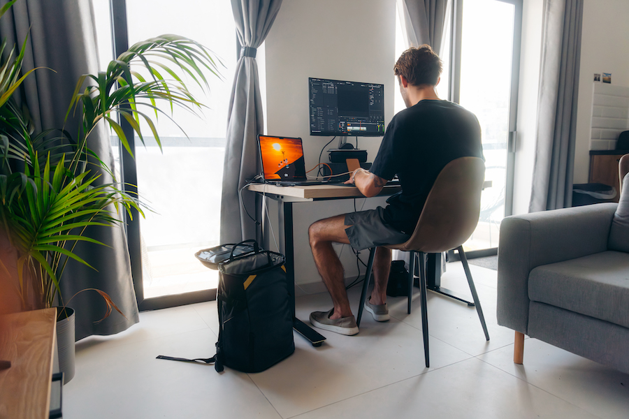 Man sitting at desk with kulkea elaa backpack upright and open beside him
